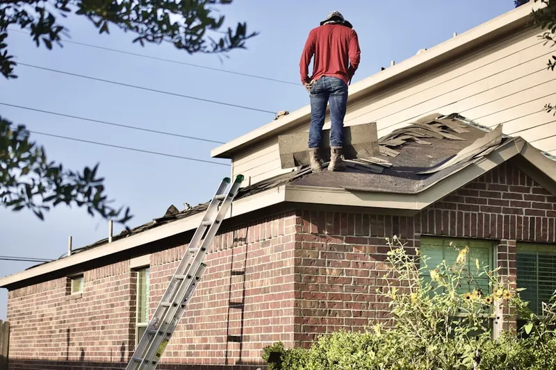 Professional roofer working on a residential roof in Ware